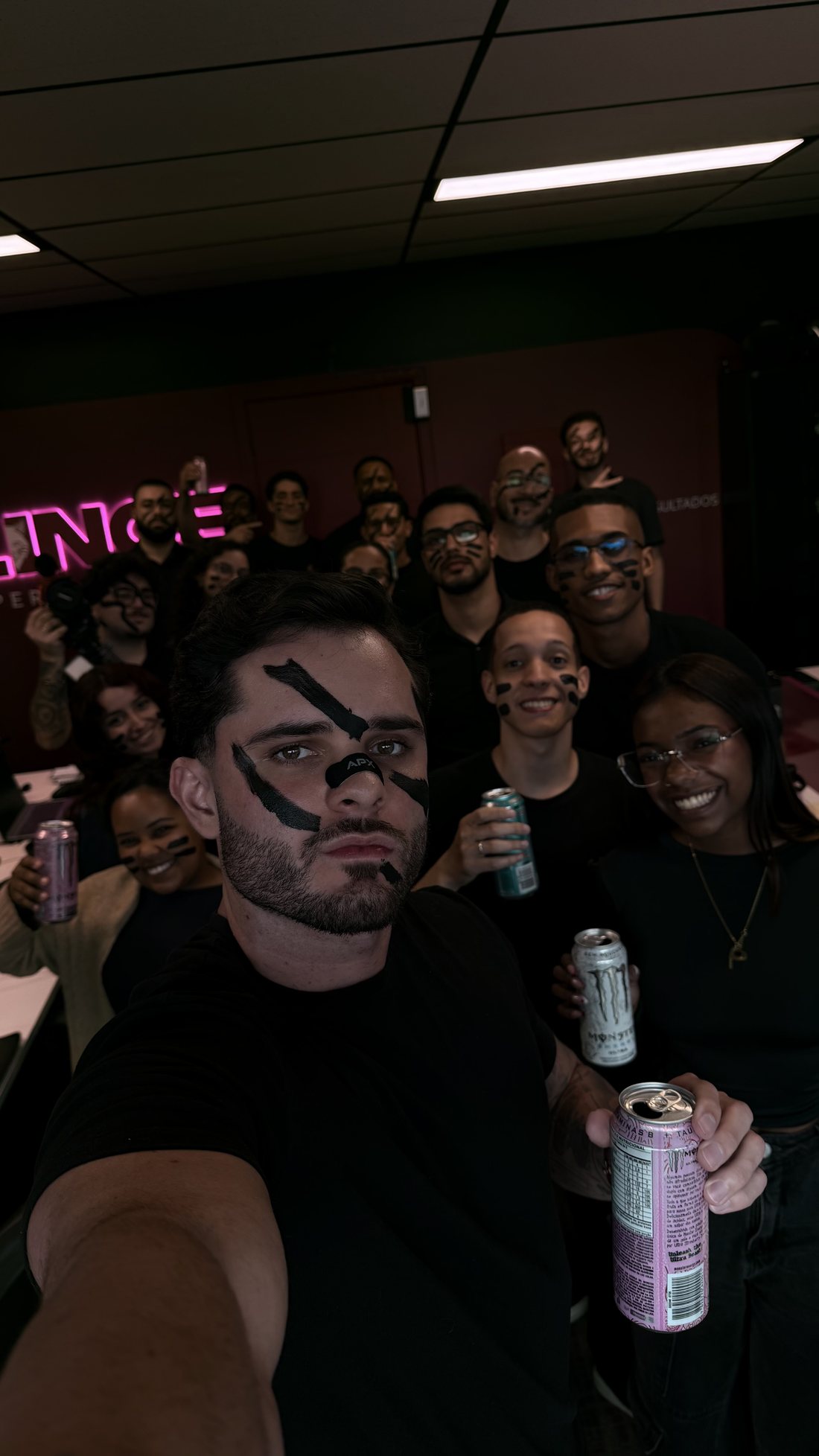 Thomas Macedo e o time da LINCE Performance no escritório, com o neon da LINCE ao fundo